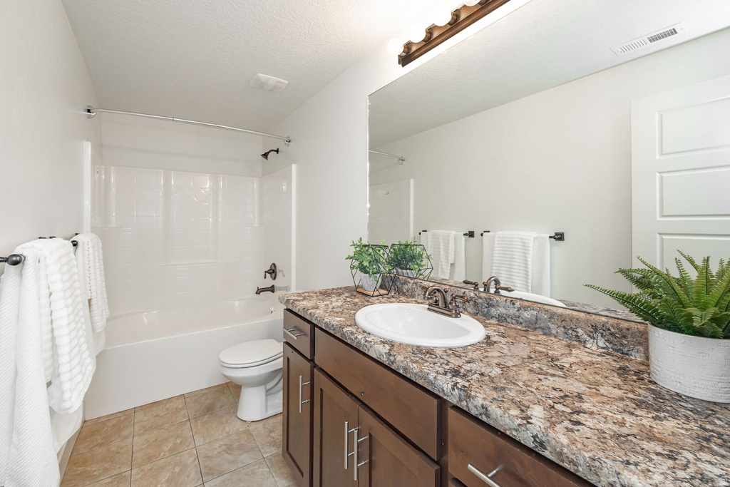 Bathroom featuring a single-sink vanity with a mottled countertop, dark wood-finish cabinetry, and a full-width mirror