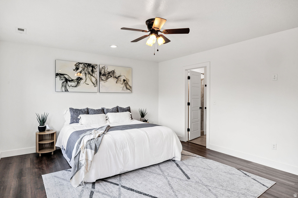Bedroom featuring wood-finish flooring, white walls, and a ceiling fan with integrated lighting