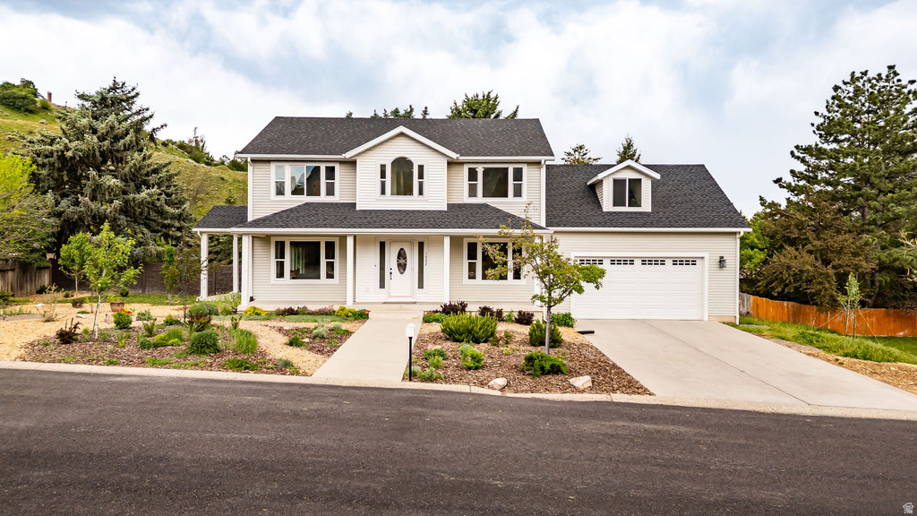 Two-story residence featuring a light-colored facade, dark shingle roof, and an attached two-car garage