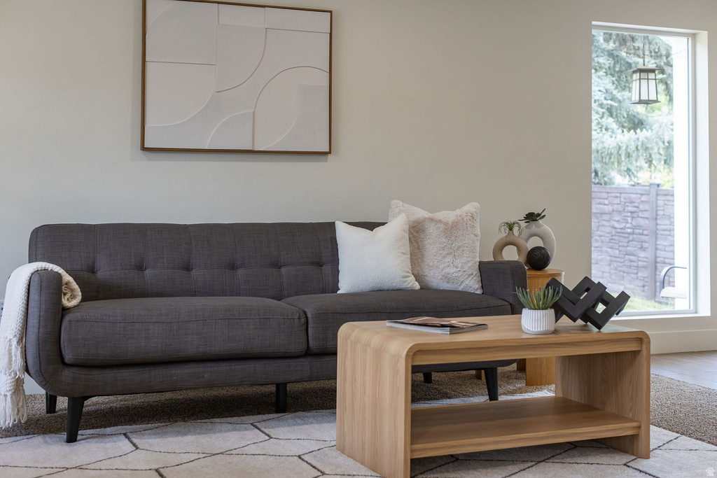 Bright interior space featuring a large picture window, light-toned walls, and a contemporary area rug