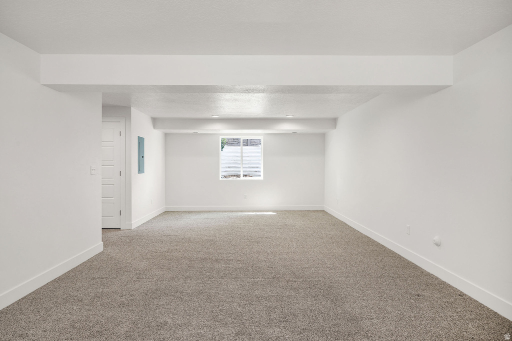 Spacious room featuring neutral carpeting and white painted walls