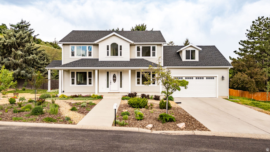 Two-story residence featuring light-colored siding, a dark shingle roof, and a prominent arched window on the upper level