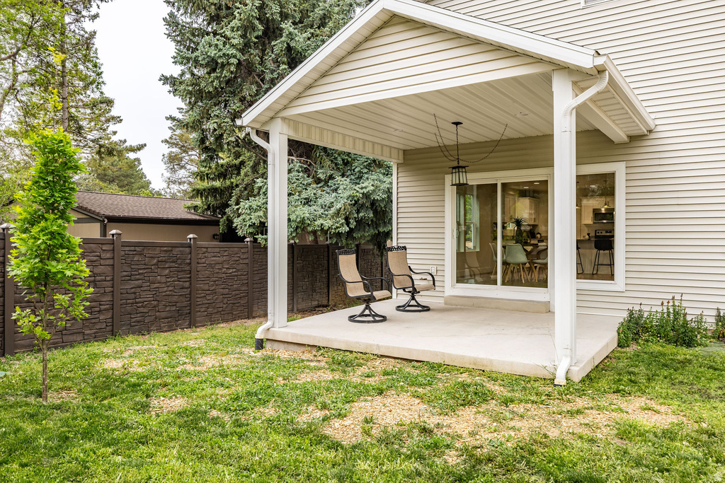 Covered concrete patio with white vinyl siding exterior