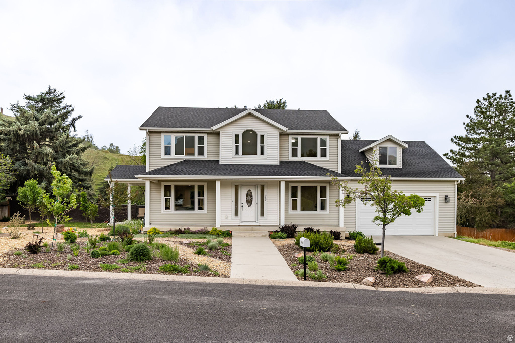 Two-story residence featuring light-colored siding, dark shingle roofing, and a prominent front entry with a white door