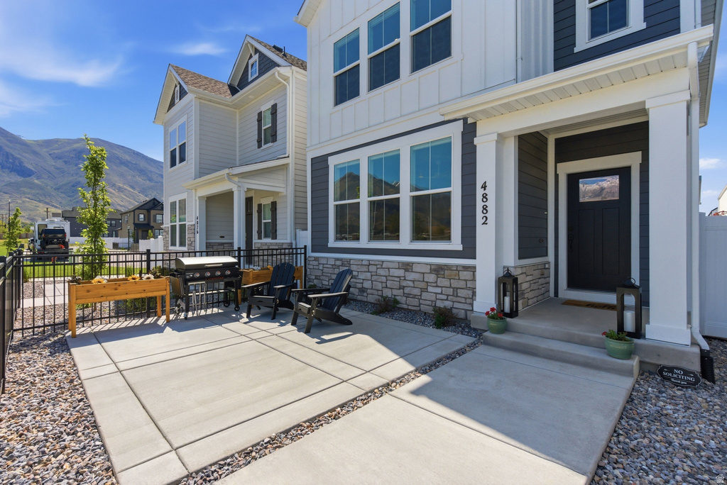 Contemporary exterior featuring charcoal siding, white board and batten accents, and a stone veneer foundation