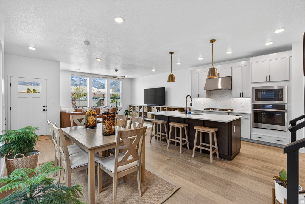 Open-concept living space featuring wood-finish flooring, recessed lighting, and a contemporary kitchen