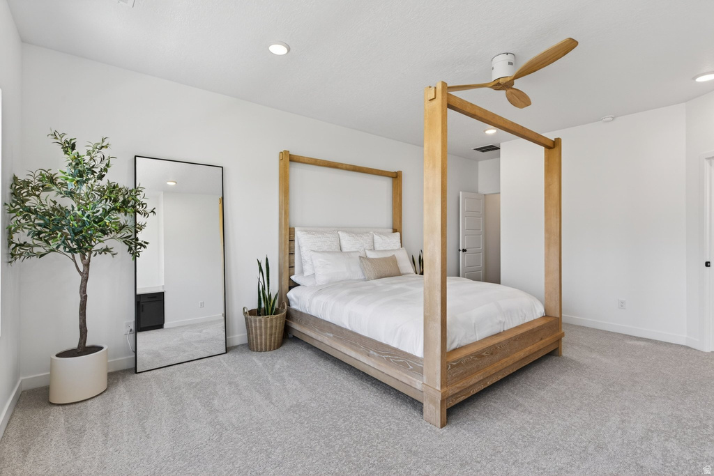 Spacious carpeted room featuring a ceiling fan with wood-finish blades, recessed lighting, and white walls