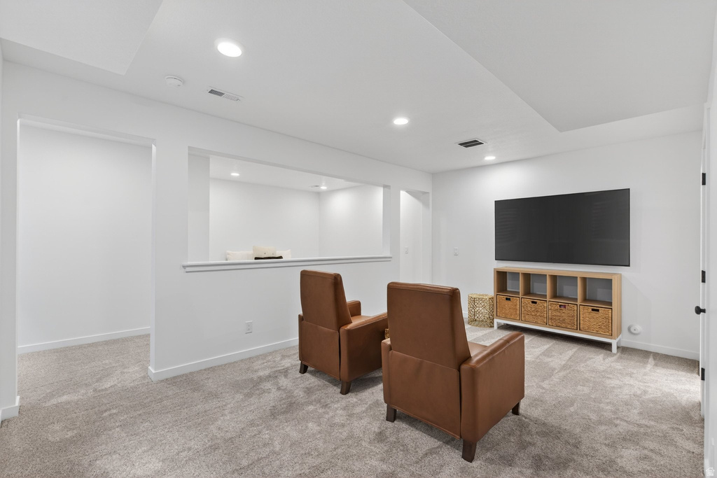 Finished lower-level space featuring recessed lighting, a neutral gray carpet, white walls, and an open wall architectural detail