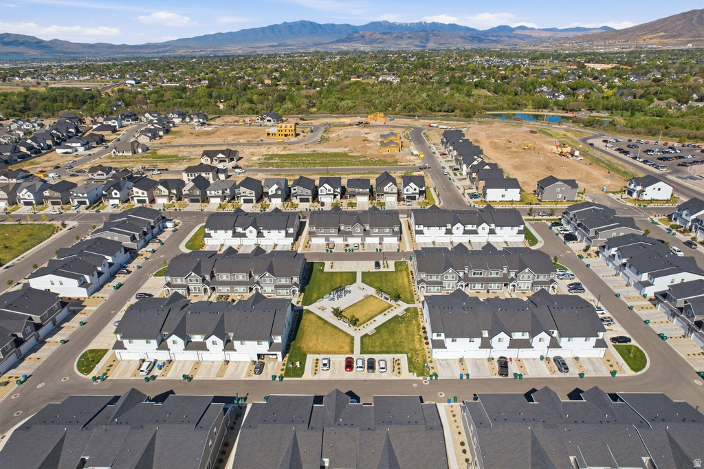 Aerial perspective of a developed community featuring various residential buildings with dark roofs and light-colored siding