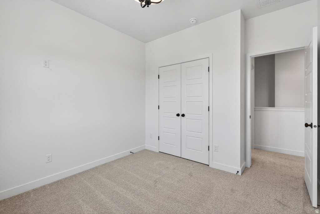Carpeted room featuring white walls, white trim, and a ceiling-mounted light fixture