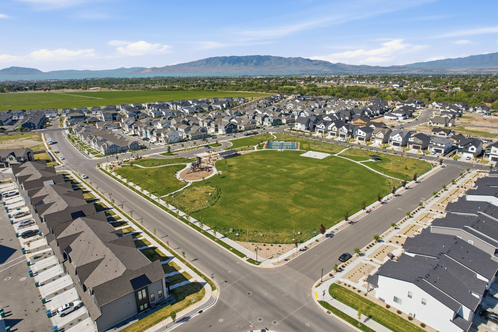 Expansive green space featuring a playground, surrounded by a residential neighborhood with new construction homes and mature landscaping