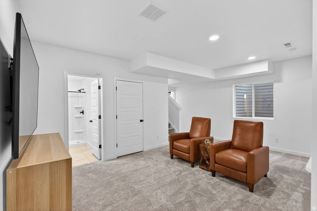 Finished lower-level space featuring plush carpeting, recessed lighting, and a white egress window