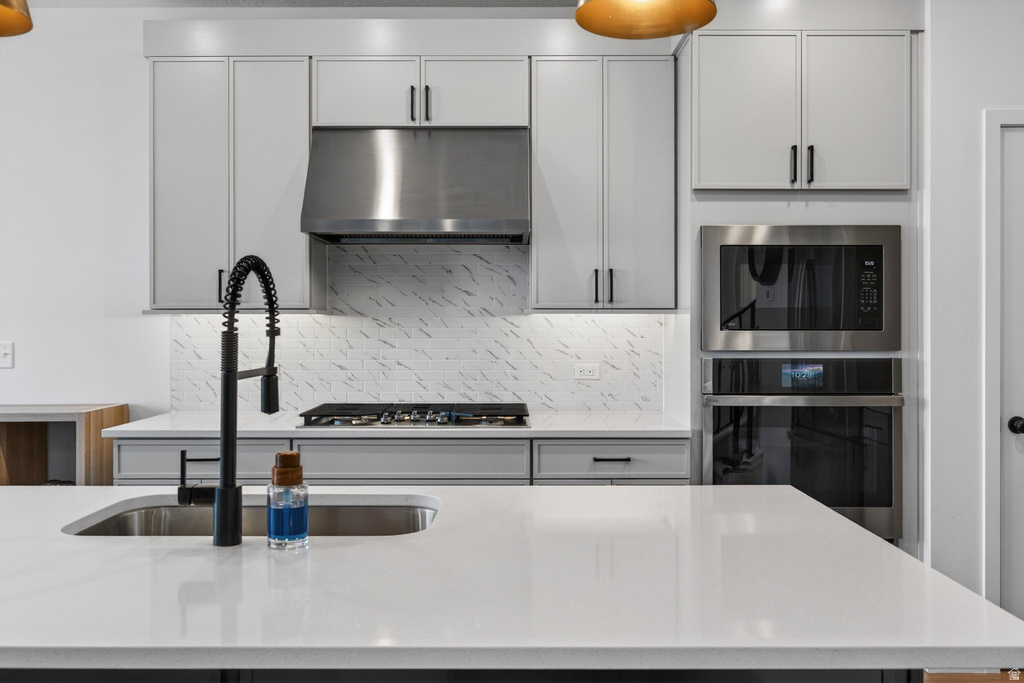 Modern kitchen featuring light gray cabinetry, stainless steel appliances, and a gas cooktop