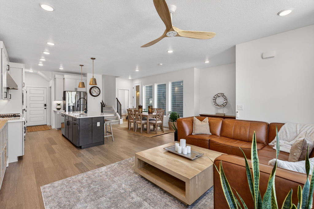 Open-concept living space featuring wood-finish flooring, recessed lighting, and a modern ceiling fan