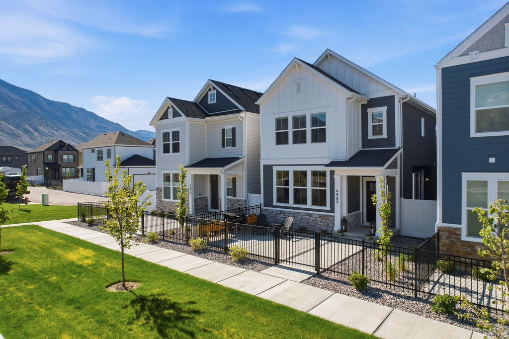 Contemporary two-story home featuring a combination of horizontal and vertical siding, stone accents, and a covered front porch