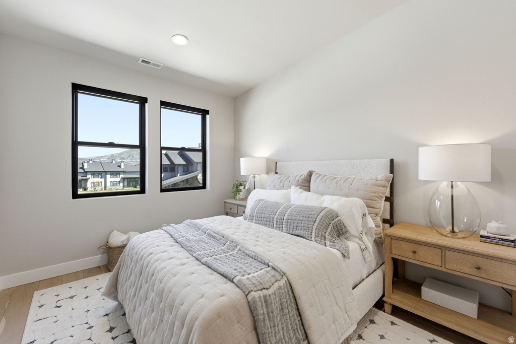Bright room featuring two large black-framed windows, recessed lighting, wood-finish flooring, and light-toned walls
