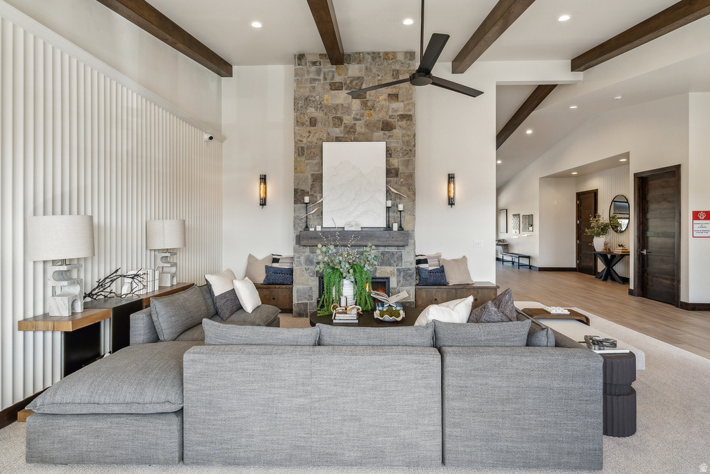 Spacious interior featuring a stone-clad fireplace, built-in bench seating, exposed wood ceiling beams, and a modern ceiling fan