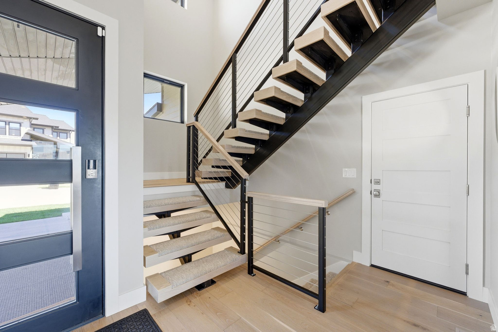 Modern staircase with open risers, black metal stringers, and light wood-finish treads