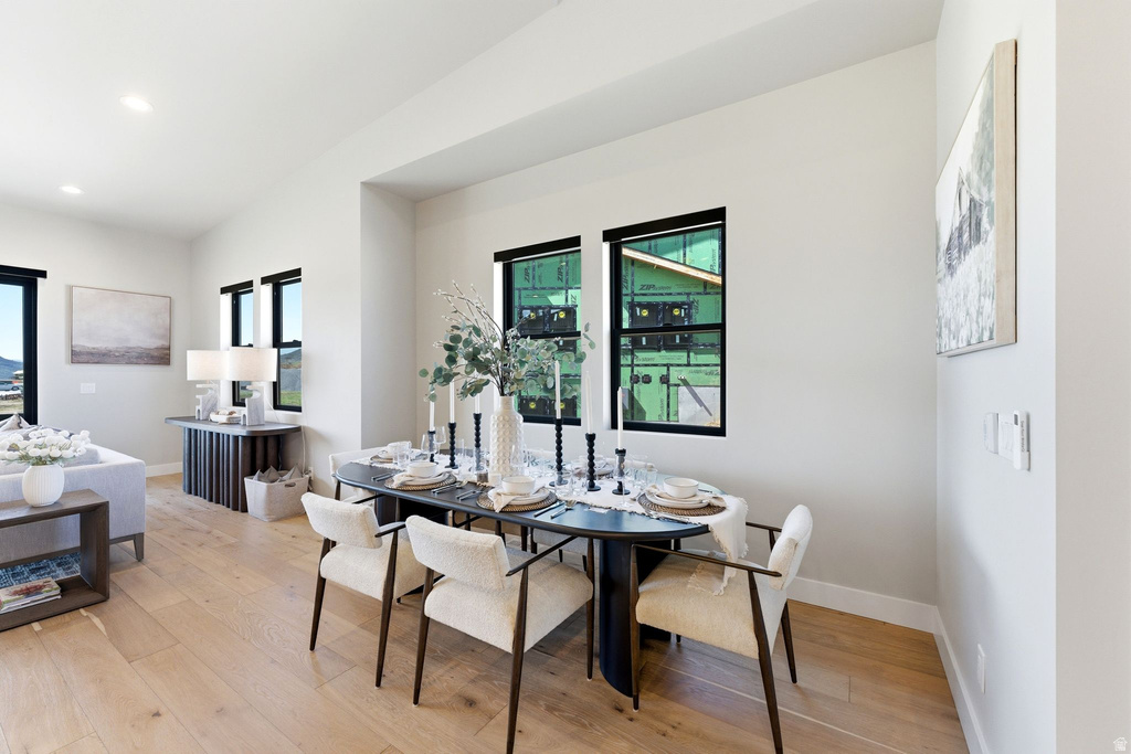 Open-concept living space featuring wood-finish flooring, recessed lighting, and multiple windows with black trim