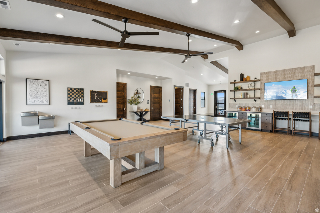 Spacious recreation room featuring wood-finish flooring, exposed beam vaulted ceilings, and recessed lighting