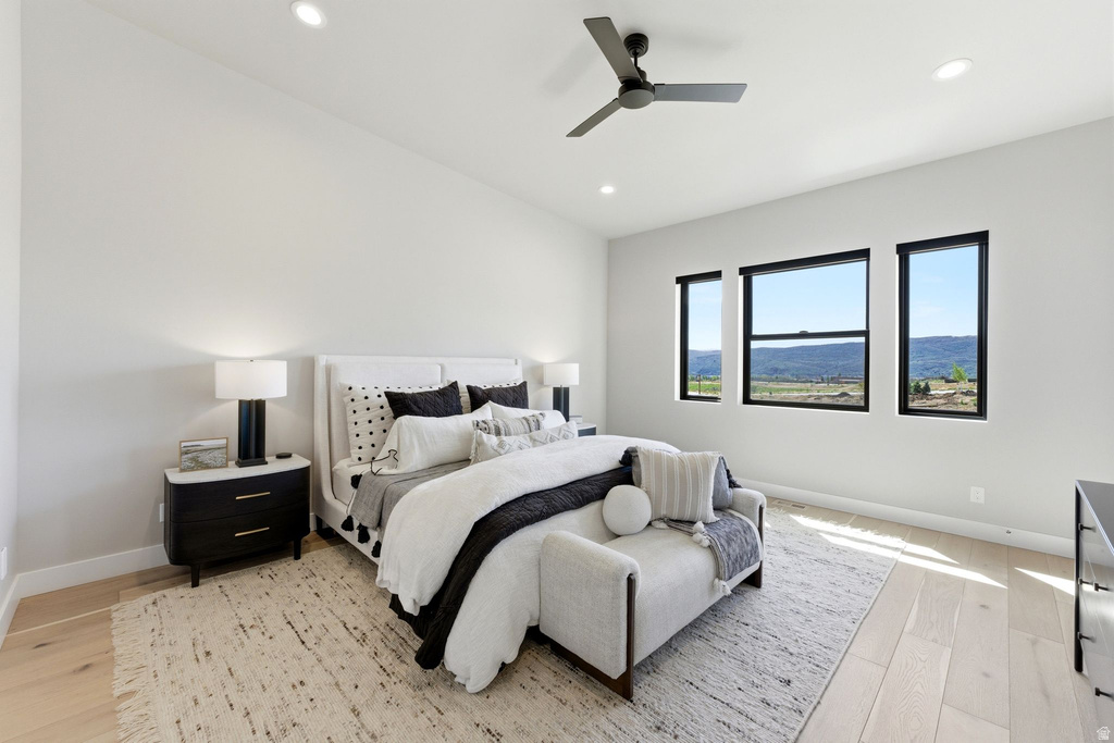 Spacious bedroom featuring light wood-finish flooring, recessed lighting, and a ceiling fan