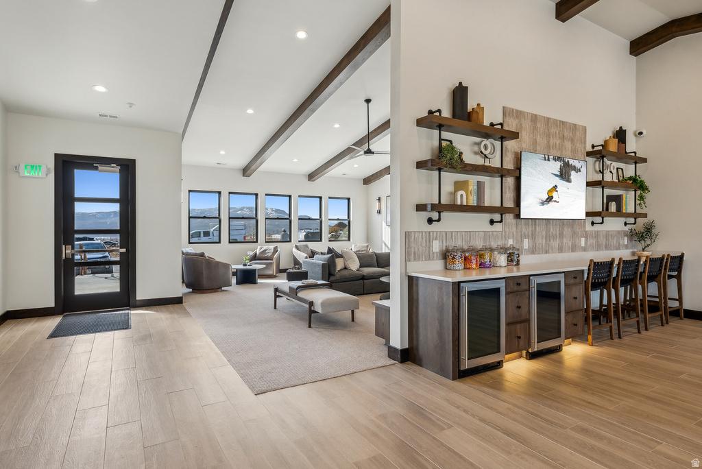 Spacious common area featuring wood-finish flooring, vaulted ceilings with exposed beams, and recessed lighting