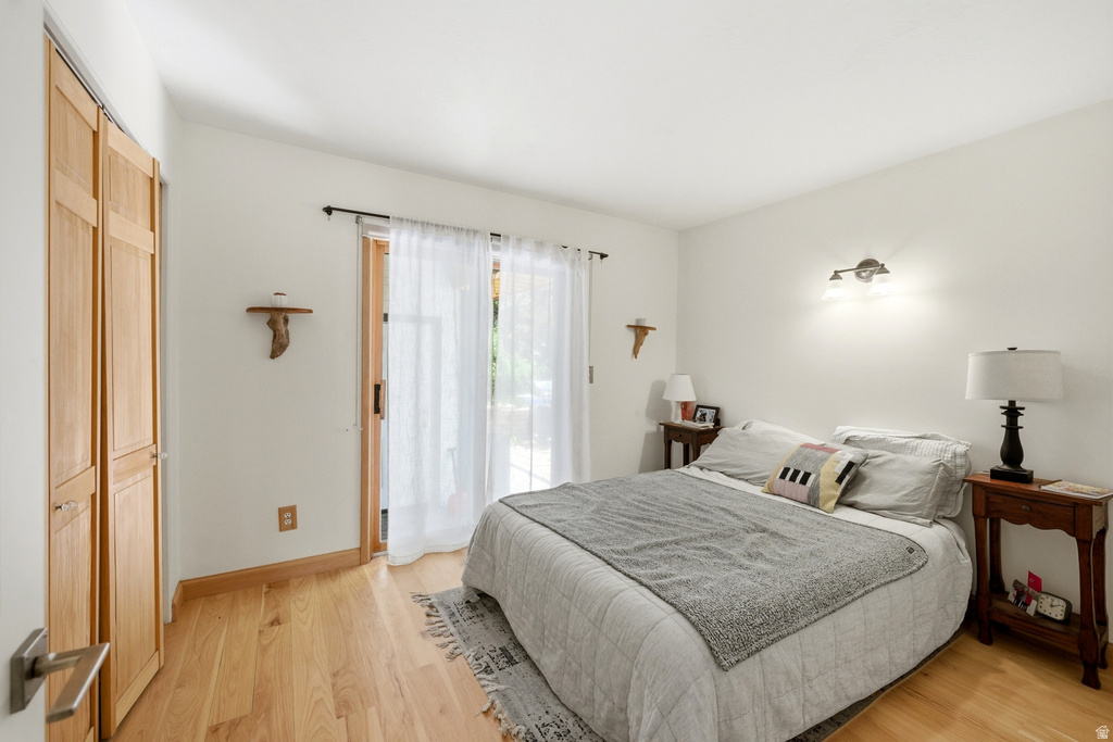 Light-filled interior space featuring wood-finish flooring, white walls, and a sliding glass door