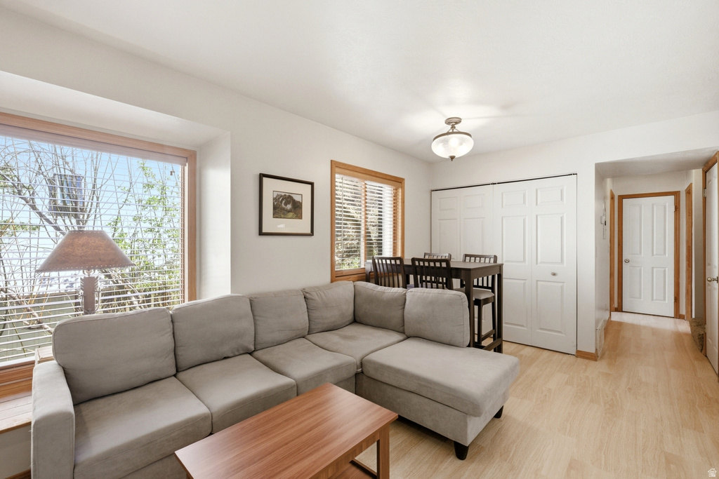 Living area featuring wood-finish flooring, a large picture window with wood trim, and a built-in window sill