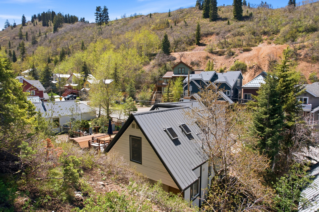 Modern A-frame style residence featuring light-colored siding and a dark gray metal roof