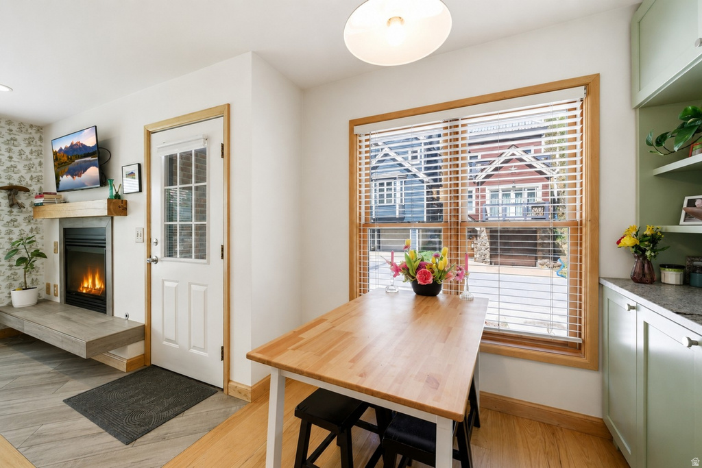 Dining nook with light wood-finish flooring and a substantial window