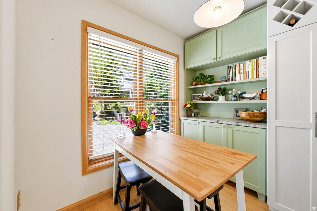Breakfast nook featuring natural wood flooring and a large window with wood blinds