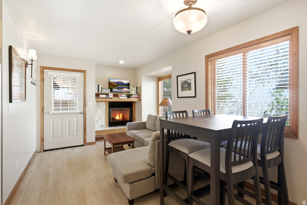 Living area with wood-finish flooring, a built-in fireplace, and a large window with wood trim
