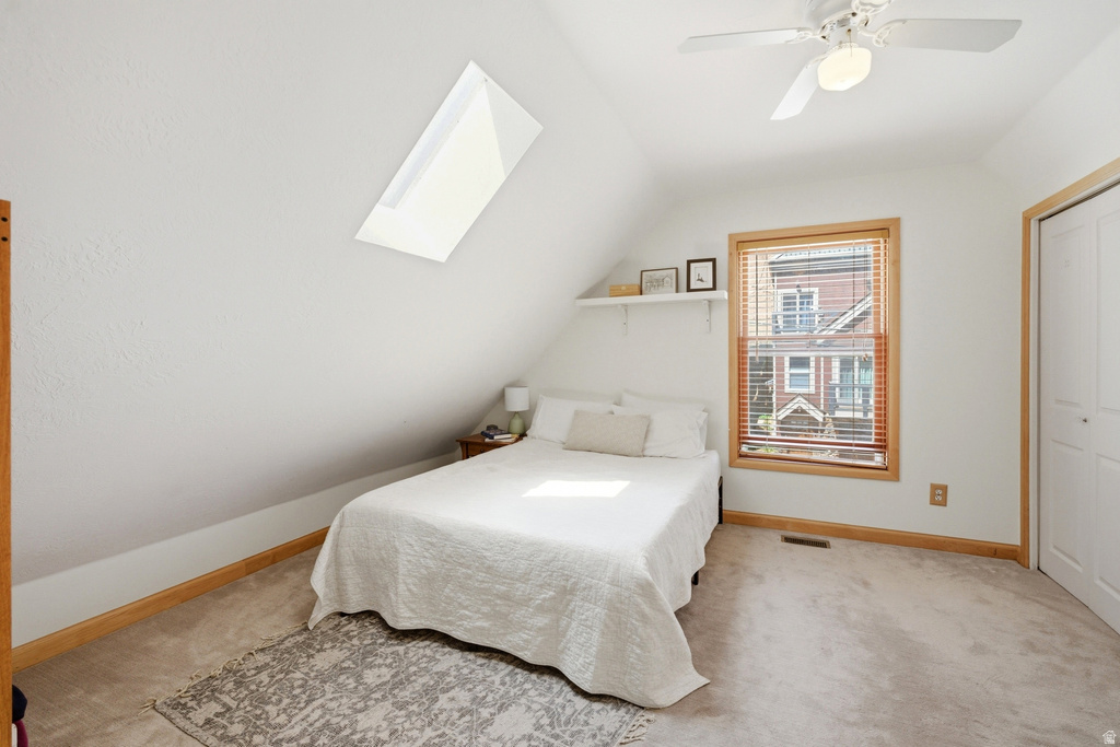 Carpeted bedroom featuring a sloped ceiling and a skylight