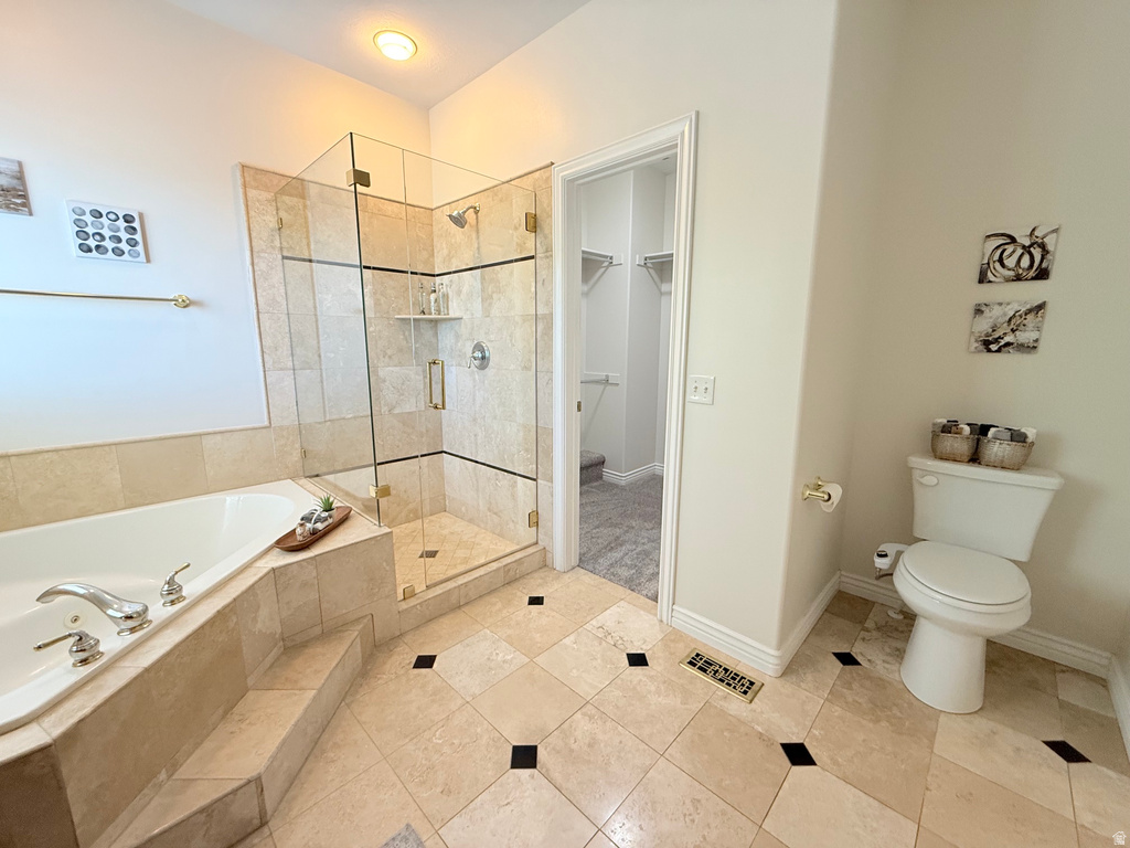 Spacious bathroom featuring a glass-enclosed walk-in shower with tile surround, a built-in soaking tub with tiled steps, and patterned tile flooring
