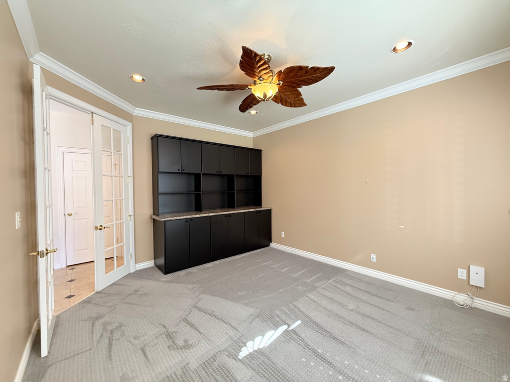 Room featuring built-in dark cabinetry with a light-toned countertop, recessed lighting, and a ceiling fan with decorative blades