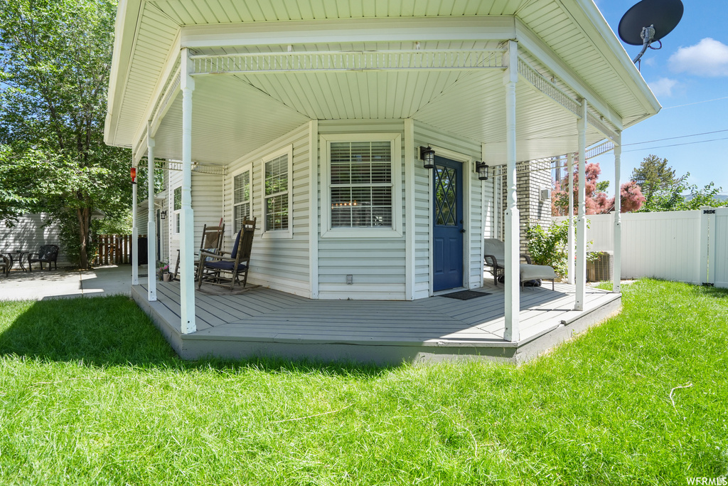 Covered porch with white columns, light blue siding, and a contrasting blue entry door