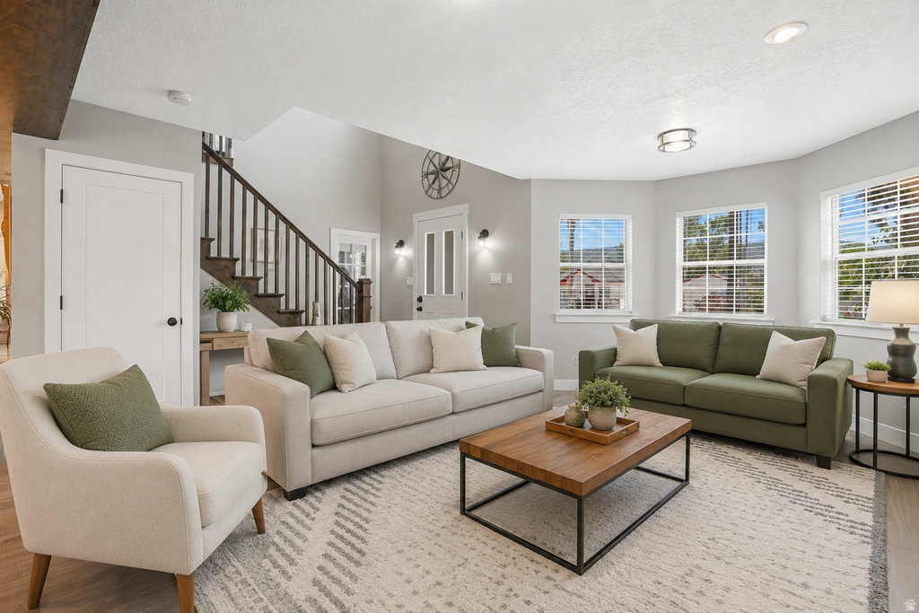 Open-concept living area featuring a vaulted ceiling and an abundance of natural light from multiple windows