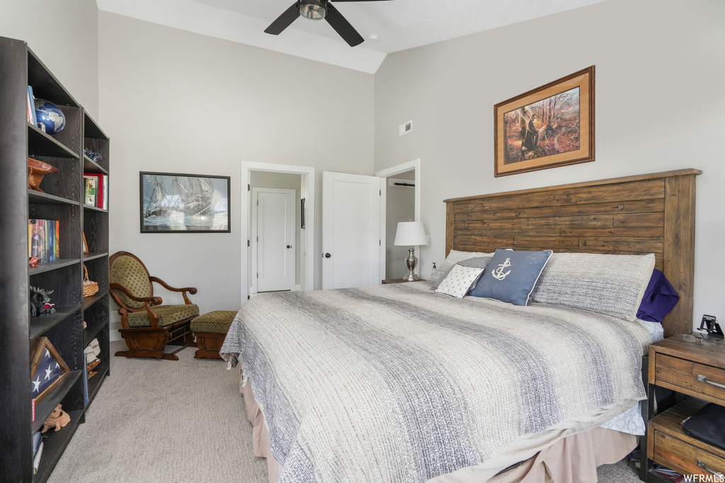 Vaulted ceiling bedroom with a wood-plank headboard and light-toned carpeting