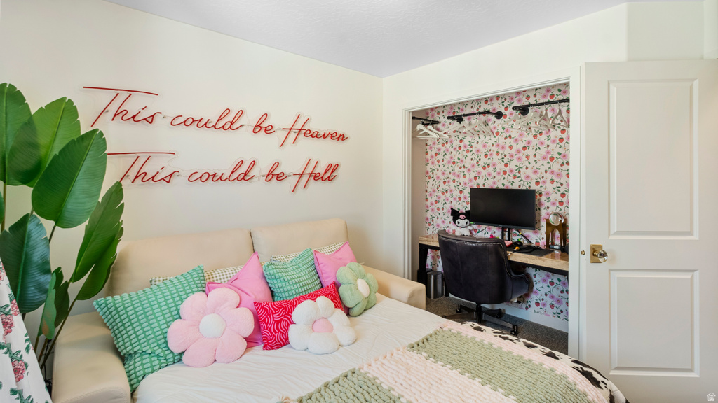 Dedicated workspace with floral wallpaper, integrated shelving, and a built-in desk