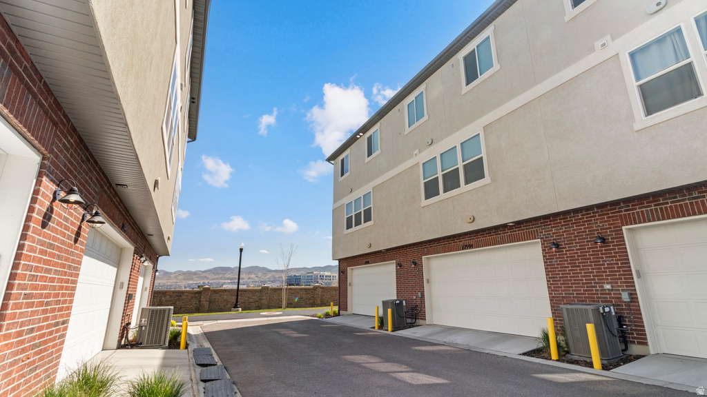 Brick and stucco exterior townhomes featuring multiple garage doors and second-story windows