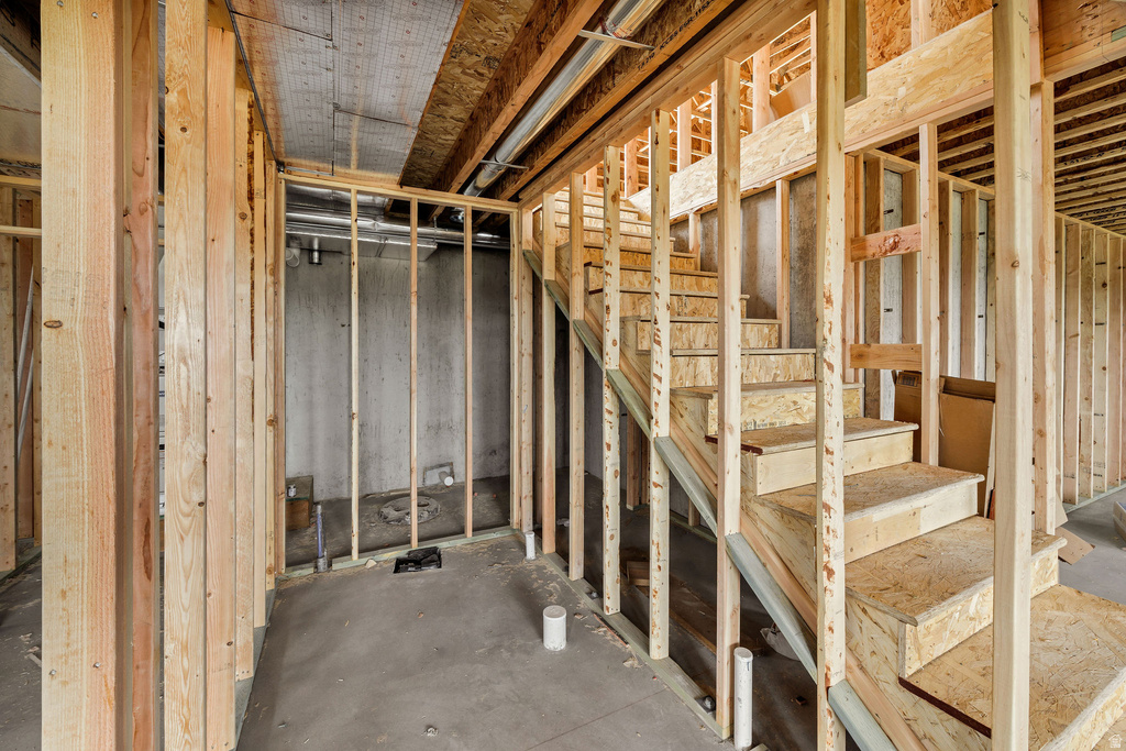 Framed staircase featuring wood construction and unfinished concrete flooring