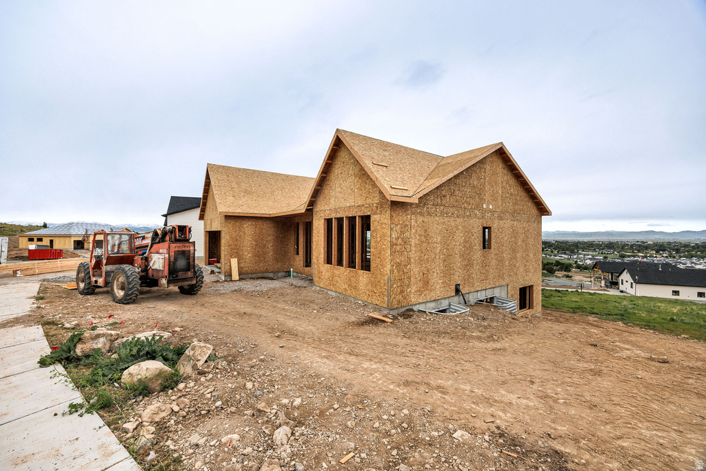 Newly constructed residential property featuring a pitched roofline and a partial foundation