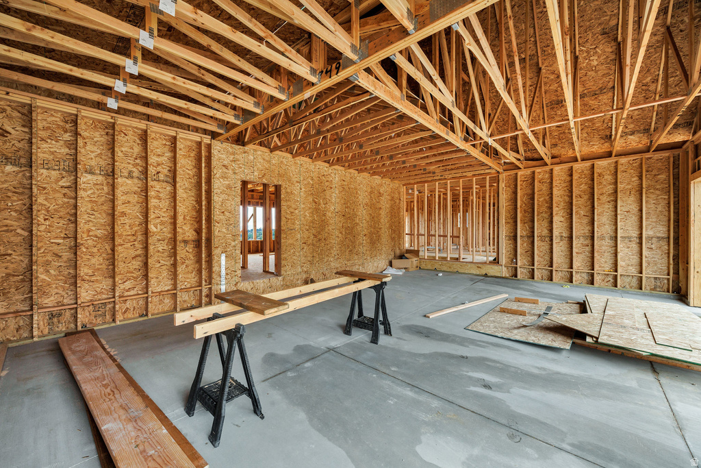 Framed interior space featuring exposed wood trusses and oriented strand board walls