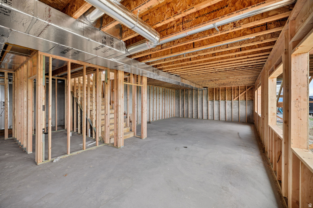 Unfinished basement space with exposed wood framing, concrete floor, and visible ductwork