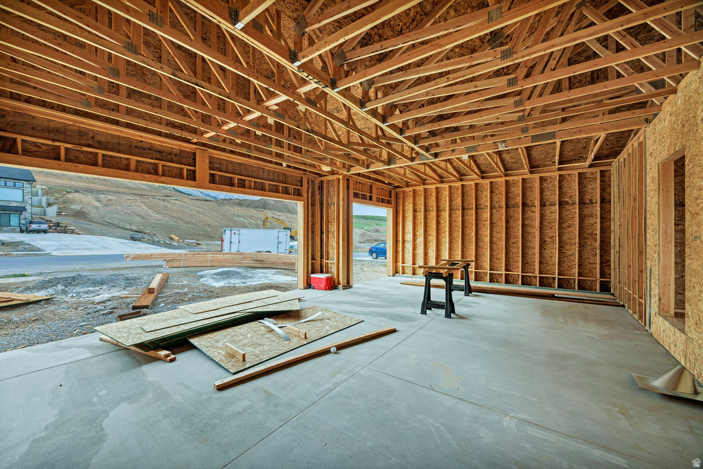 Garage interior featuring exposed wood framing and concrete flooring