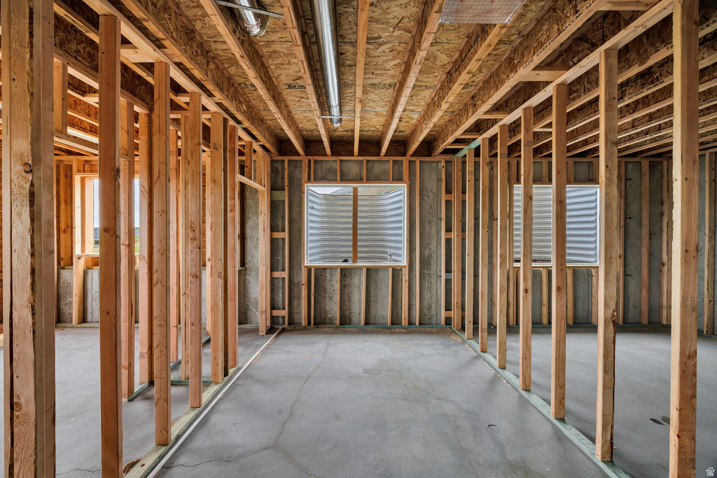 Unfinished lower level featuring wood framing, concrete flooring, and multiple egress windows