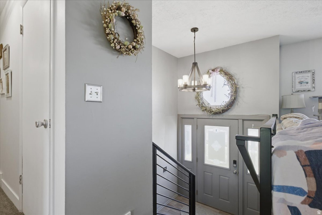 Entryway featuring a gray door with frosted glass panels, an adjacent sidelight, and a contemporary chandelier