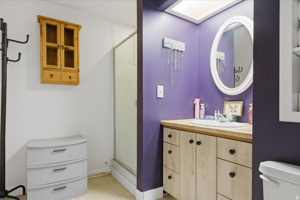 Bathroom featuring a shower enclosure, a vanity with a drop-in sink, and a framed oval mirror