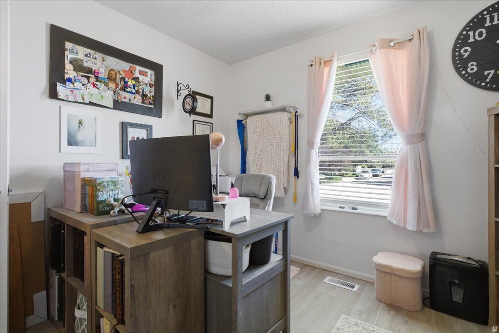 Dedicated room featuring wood-finish flooring, a window with blinds, and light-colored wall paint