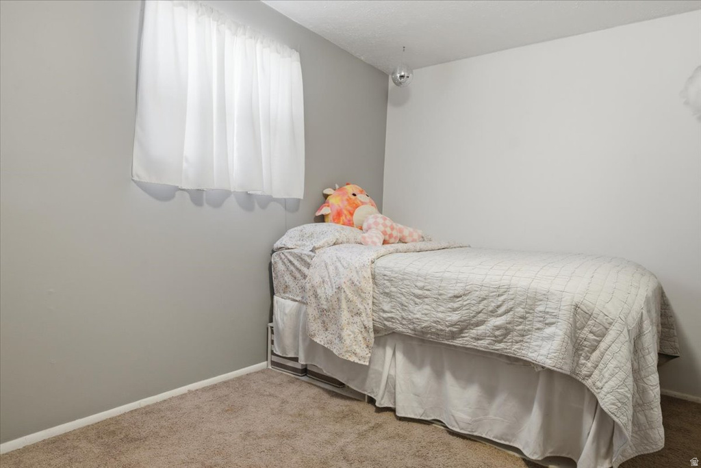 Carpeted room featuring a window with white curtains, two-tone painted walls, and white baseboards